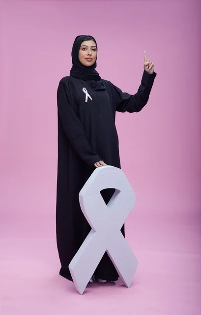 امرأة سعودية مع رمز التوعية بسرطان الثدي