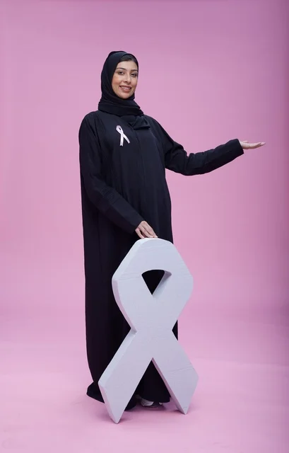 امرأة سعودية مع رمز التوعية بسرطان الثدي