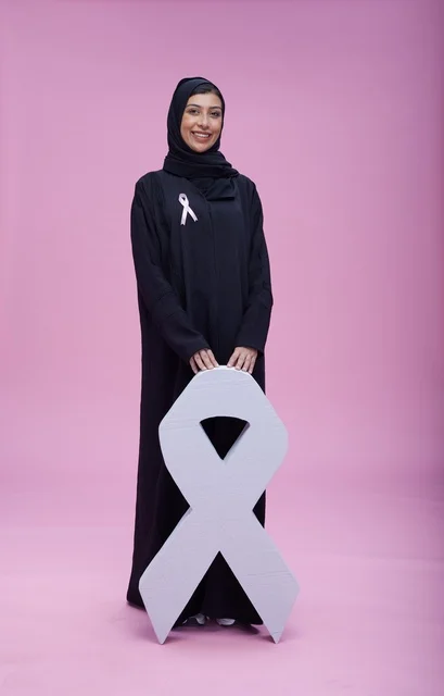 امرأة سعودية مع رمز التوعية بسرطان الثدي