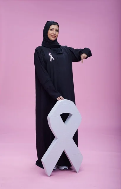 امرأة سعودية مع رمز التوعية بسرطان الثدي