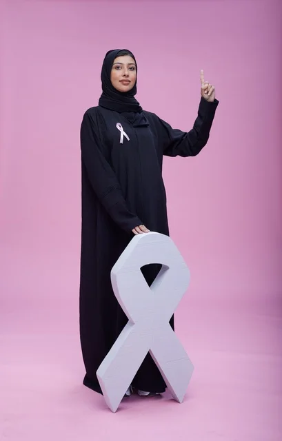 امرأة سعودية مع رمز التوعية بسرطان الثدي
