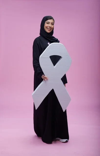 امرأة سعودية تحمل رمز التوعية بسرطان الثدي