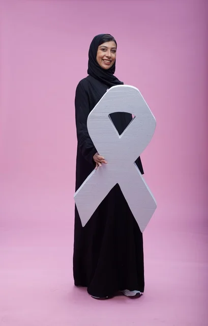 امرأة سعودية تحمل رمز التوعية بسرطان الثدي