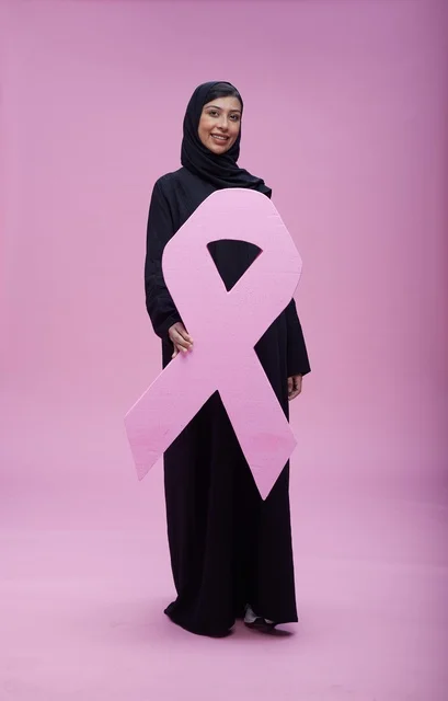 امرأة سعودية تحمل شعار التوعية بسرطان الثدي