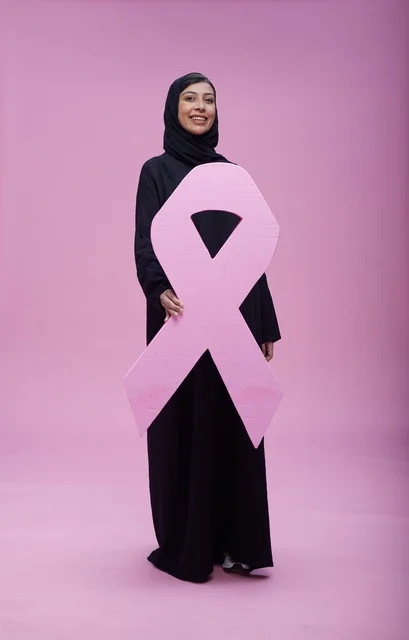 امرأة سعودية مع رمز التوعية بسرطان الثدي