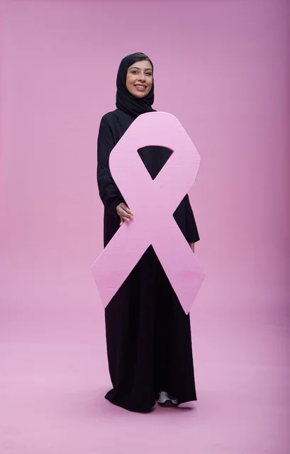 امرأة سعودية تحمل شريط التوعية بسرطان الثدي