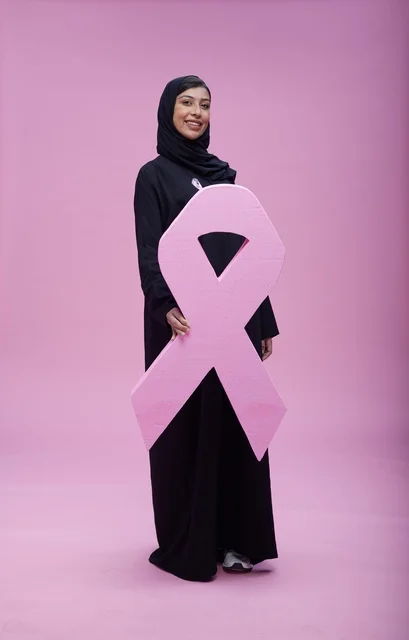 امرأة سعودية مع رمز التوعية بسرطان الثدي