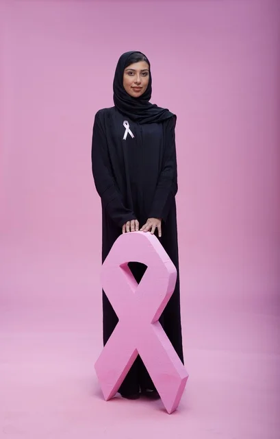 امرأة سعودية مع رمز التوعية بسرطان الثدي الوردي