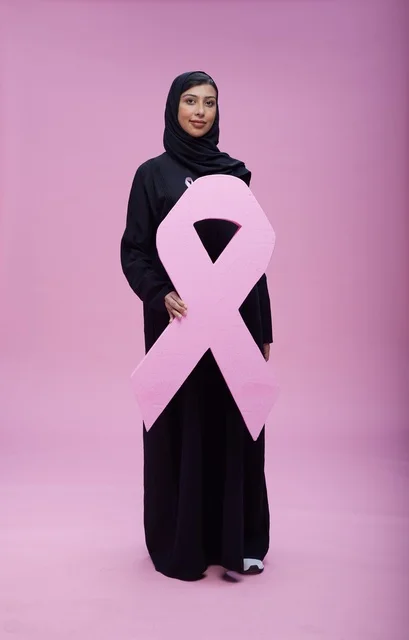 امرأة سعودية تحمل رمز التوعية بسرطان الثدي