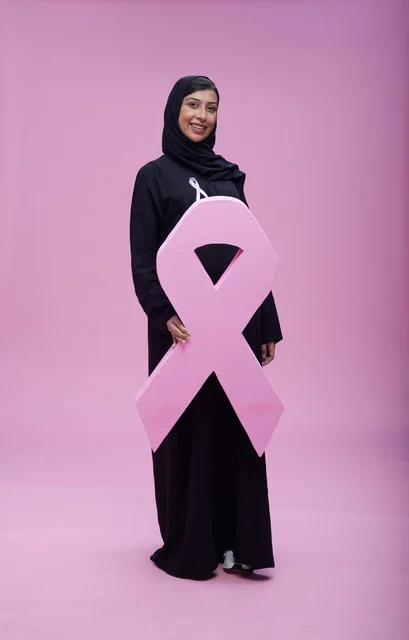 امرأة سعودية تحمل رمز التوعية بسرطان الثدي