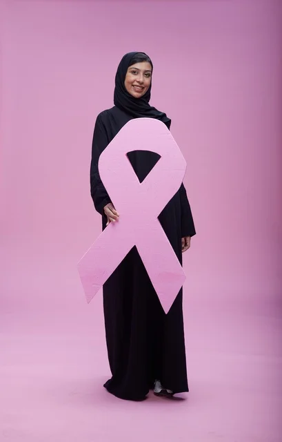 امرأة سعودية تحمل شعار التوعية بسرطان الثدي