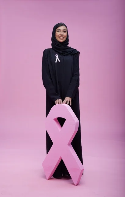 امرأة سعودية مع رمز التوعية العالمي لسرطان الثدي