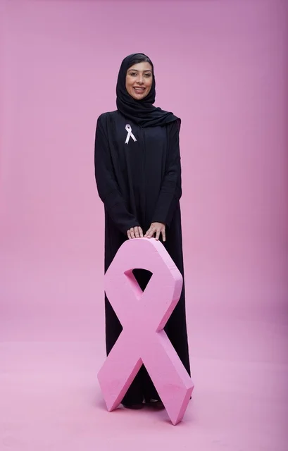 امرأة سعودية مع شريط التوعية بسرطان الثدي الوردي