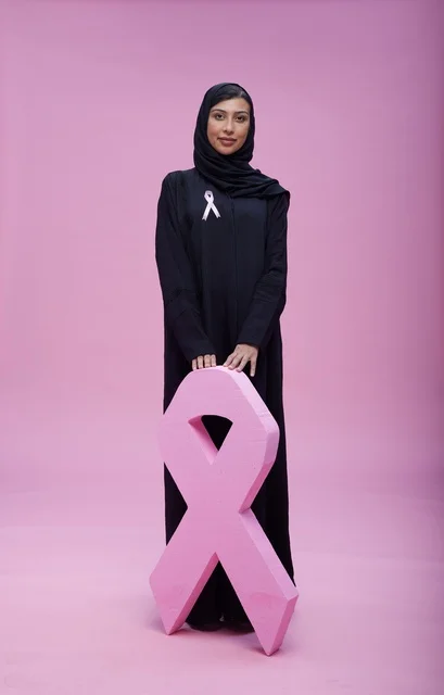 امرأة سعودية مع شعار التوعية بسرطان الثدي الوردي