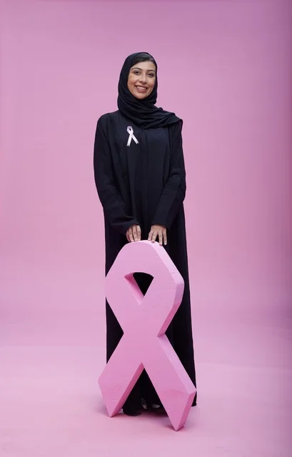 امرأة سعودية مع رمز التوعية بسرطان الثدي