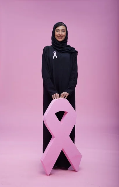 امرأة سعودية مع رمز التوعية بسرطان الثدي