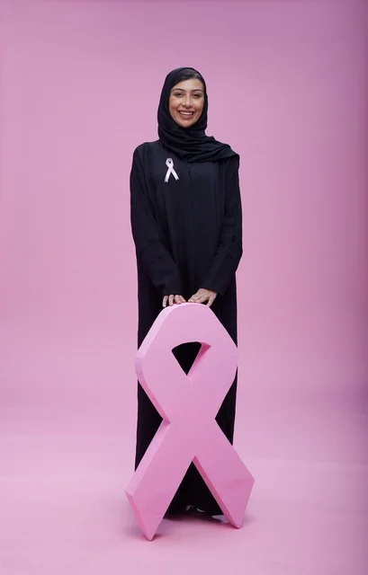 امرأة سعودية مع رمز التوعية بسرطان الثدي