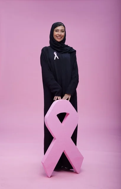 امرأة سعودية مع شعار التوعية بسرطان الثدي