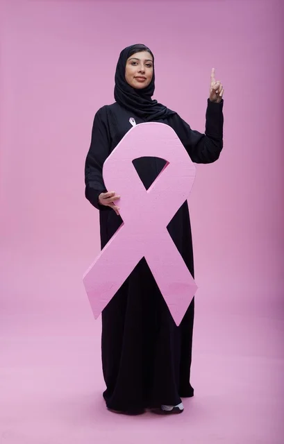 امرأة سعودية مع رمز التوعية بسرطان الثدي