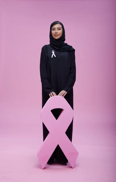 امرأة سعودية مع رمز التوعية بسرطان الثدي