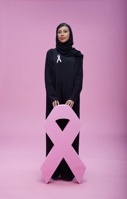امرأة سعودية مع رمز التوعية بسرطان الثدي في استوديو