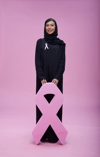 امرأة سعودية مع شعار التوعية بسرطان الثدي