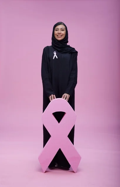 امرأة سعودية مع شعار التوعية بسرطان الثدي