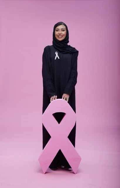 امرأة سعودية مع رمز التوعية بسرطان الثدي الوردي
