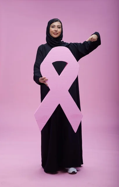 امرأة سعودية تحمل شعار التوعية بسرطان الثدي