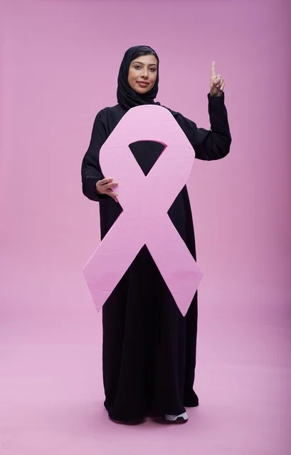 امرأة سعودية تحمل شعار التوعية بمرض سرطان الثدي