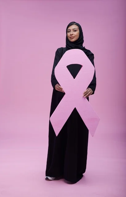 امرأة سعودية تحمل شعار التوعية بسرطان الثدي