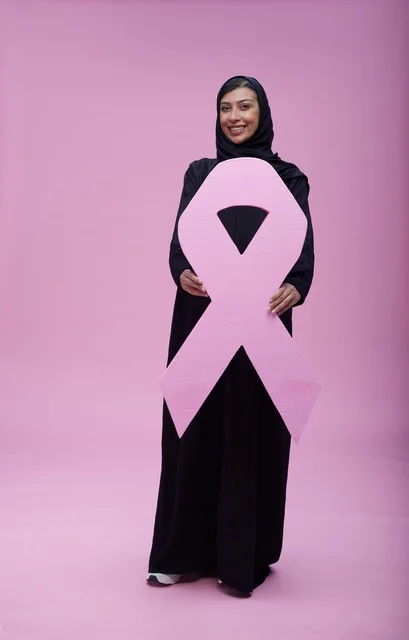 امرأة سعودية تحمل شعار التوعية بسرطان الثدي