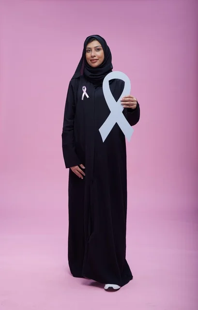 امرأة سعودية مع شعار التوعية بسرطان الثدي