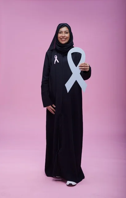 امرأة سعودية تحمل شعار التوعية بسرطان الثدي