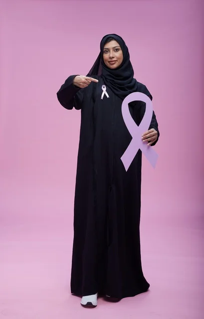 امرأة سعودية تحمل شريط التوعية الوردي لسرطان الثدي