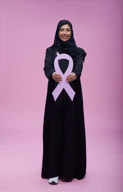 امرأة سعودية تحمل شريط التوعية بسرطان الثدي