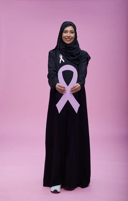 امرأة سعودية مع رمز التوعية بسرطان الثدي