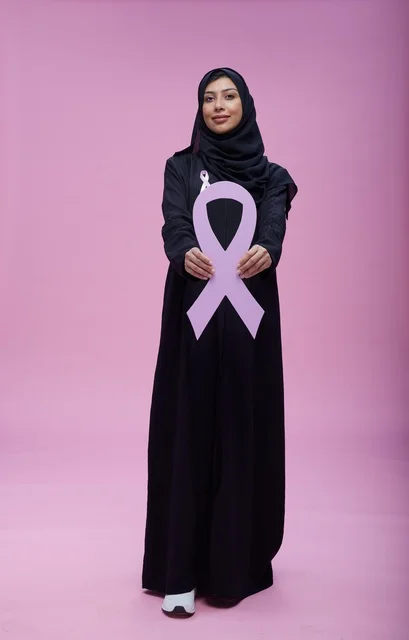 Saudi woman pointing at breast cancer awareness ribbon