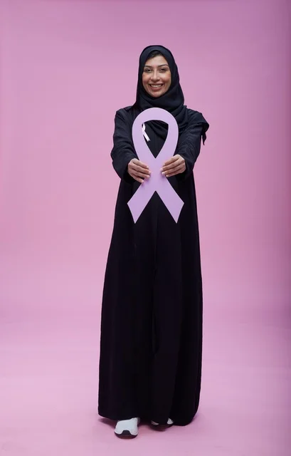 امرأة سعودية تحمل رمز التوعية بسرطان الثدي الوردي