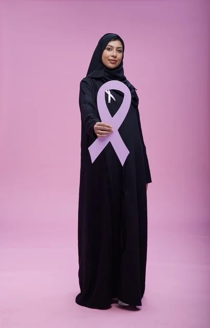 امرأة سعودية تحمل شريط التوعية بمرطان الثدي