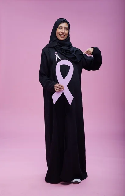 Saudi woman pointing at breast cancer awareness ribbon