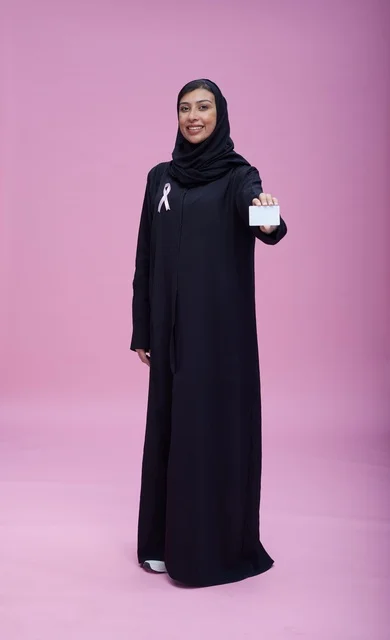 Saudi woman showing card for breast cancer awareness