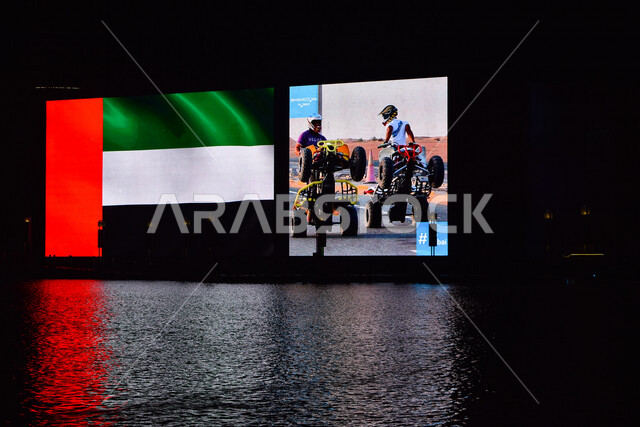 صورة ليلية لانعكاس علم الإمارات في مياه نافورة دبي مول بإمارة دبي ، لوحة إعلانات ، معالم الإمارات المشهورة ، السياحة في الإمارات العربية المتحدة.