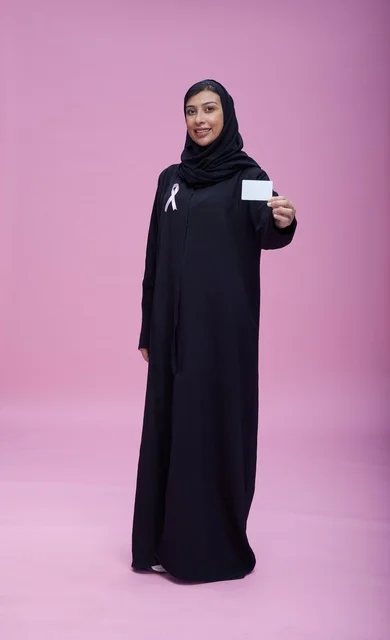 Saudi Woman Holding Blank Card for Breast Cancer Awareness