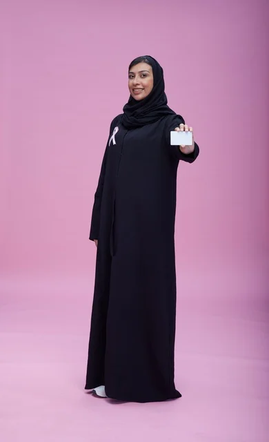 امرأة سعودية تحمل بطاقة التوعية بسرطان الثدي