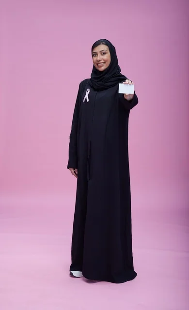 امرأة سعودية مع شريط التوعية بسرطان الثدي