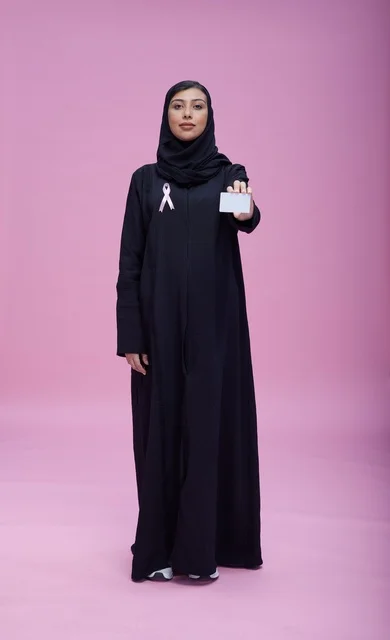 امرأة سعودية بشريط سرطان الثدي وتحمل بطاقة فارغة