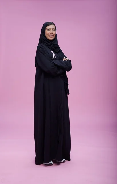 امرأة سعودية تدعم التوعية بسرطان الثدي بخلفية وردية