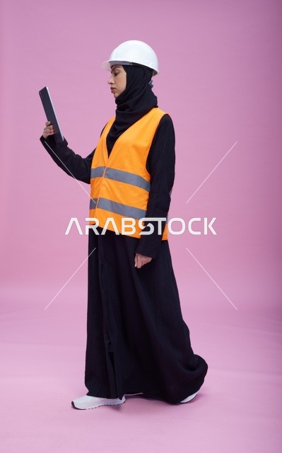 مهندسة سعودية مع جهاز لوحي بمعدات السلامة