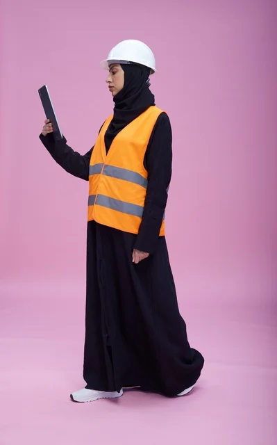 مهندسة سعودية مع جهاز لوحي بمعدات السلامة